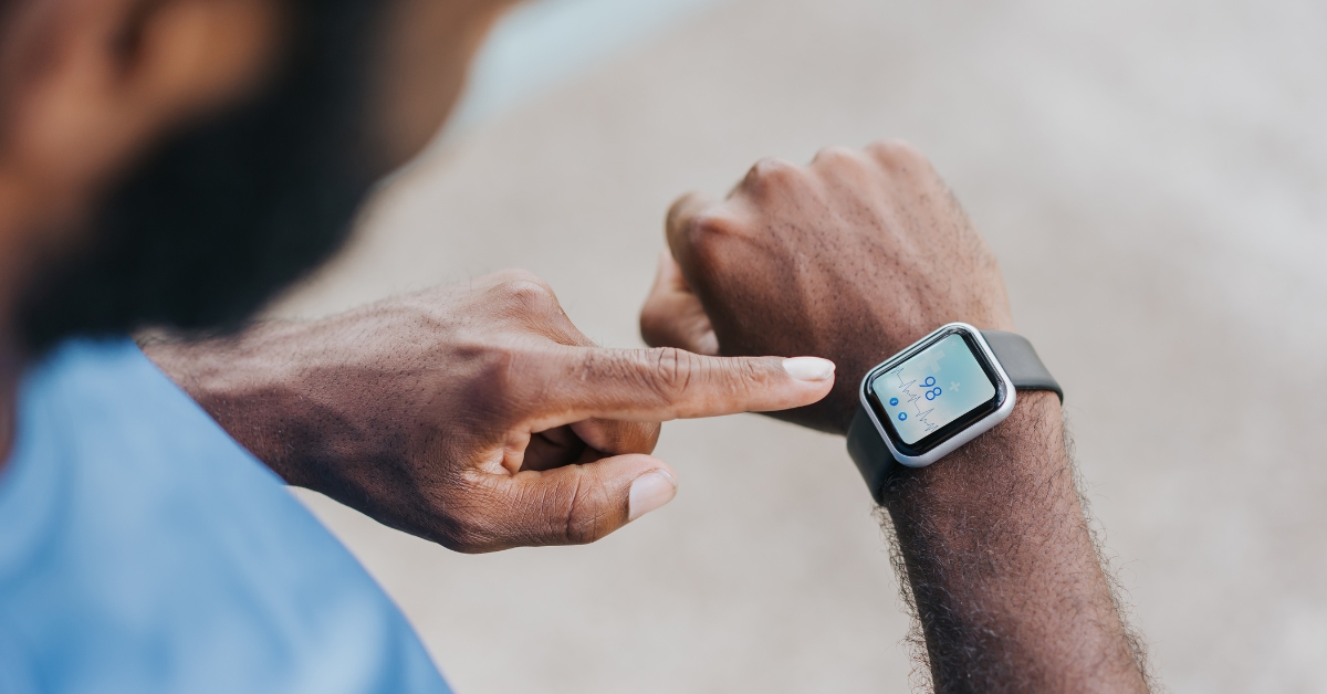 Person checking smartwatch displaying heart rate data to monitor stress and heart rate patterns